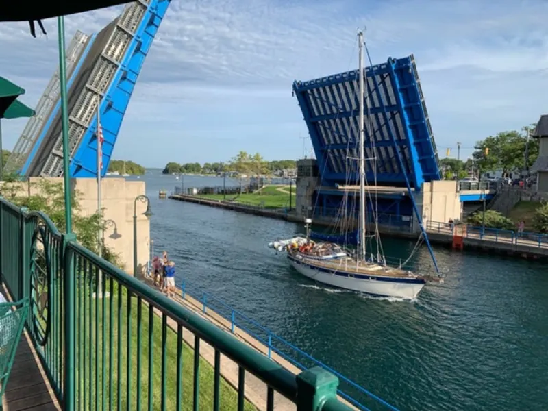A sailboat mast passing the raised drawbridge